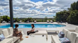 Participantes installées au bord d'une piscine sous un ciel nuageux