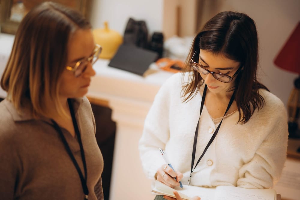 Deux participantes prennent des notes pendant une formation coaching