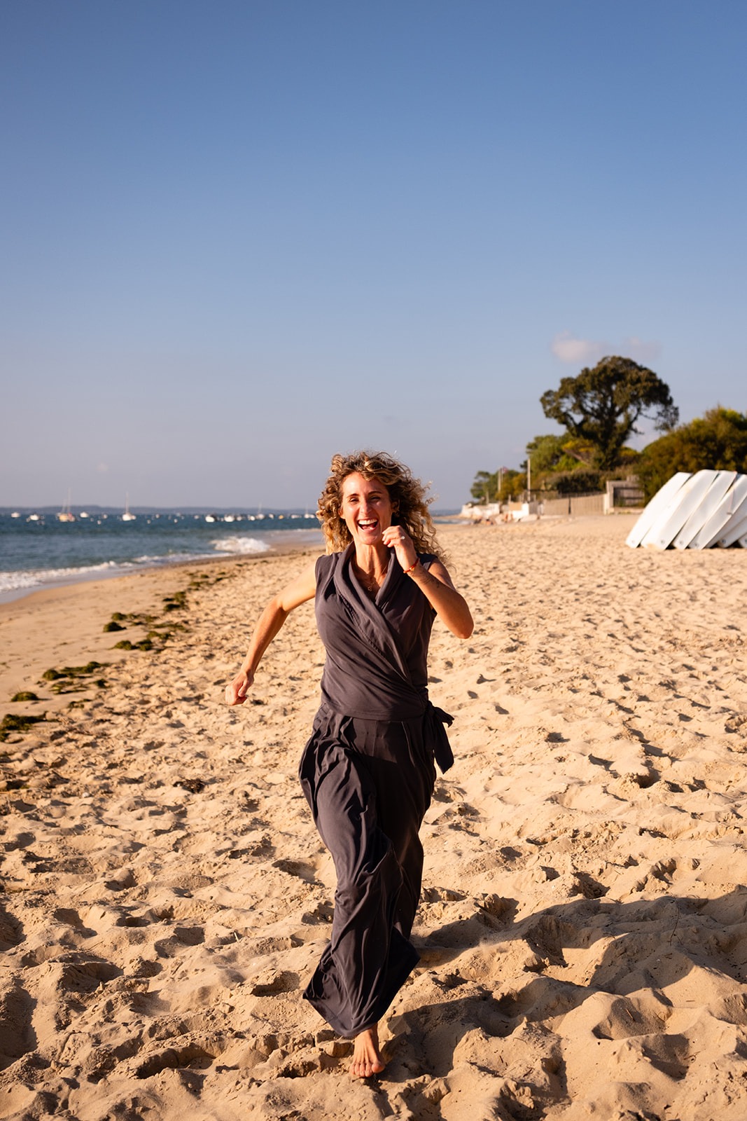 Juliette Zurstrassen, naturopathe et coach, court en riant sur une plage